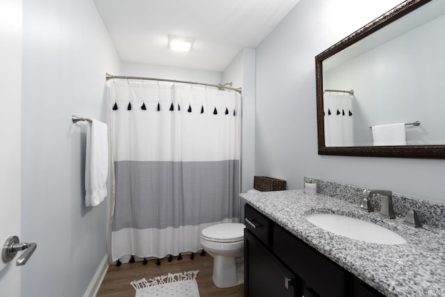 bathroom featuring toilet, vanity, walk in shower, and hardwood / wood-style floors