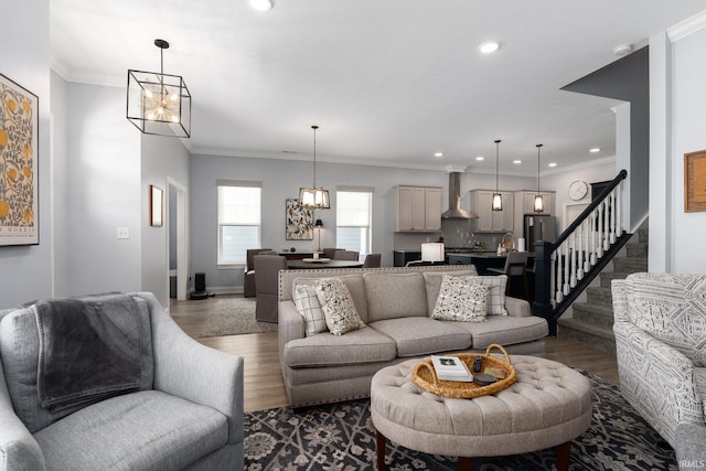 living room featuring crown molding, wood-type flooring, and an inviting chandelier