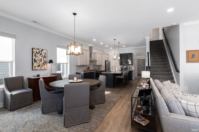 dining area featuring a chandelier, crown molding, and wood-type flooring