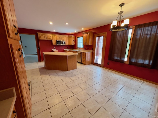 kitchen with decorative light fixtures, a center island, sink, stainless steel appliances, and a chandelier