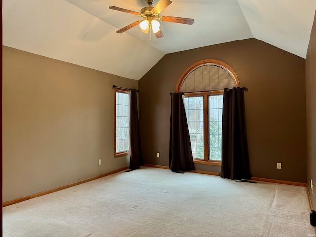 spare room with ceiling fan, lofted ceiling, and light colored carpet