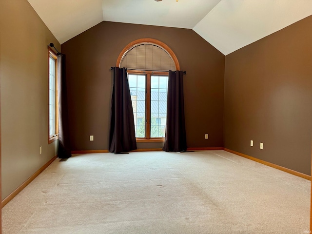 carpeted empty room with ceiling fan and lofted ceiling