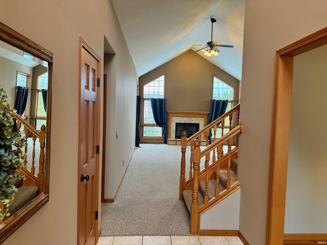 hallway with lofted ceiling and light colored carpet