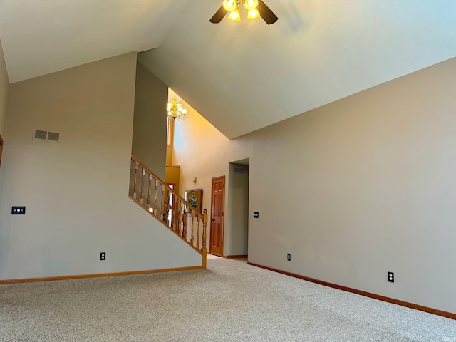 unfurnished living room featuring ceiling fan with notable chandelier, high vaulted ceiling, and carpet floors