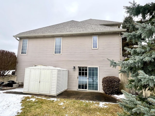 back of house featuring a storage shed