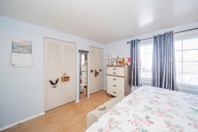 bedroom featuring light hardwood / wood-style flooring and multiple closets