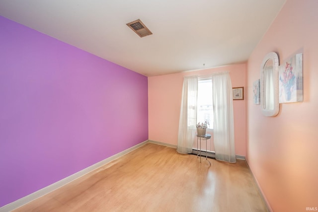 empty room featuring light hardwood / wood-style floors and a baseboard radiator