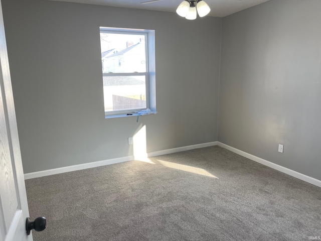 carpeted spare room featuring ceiling fan