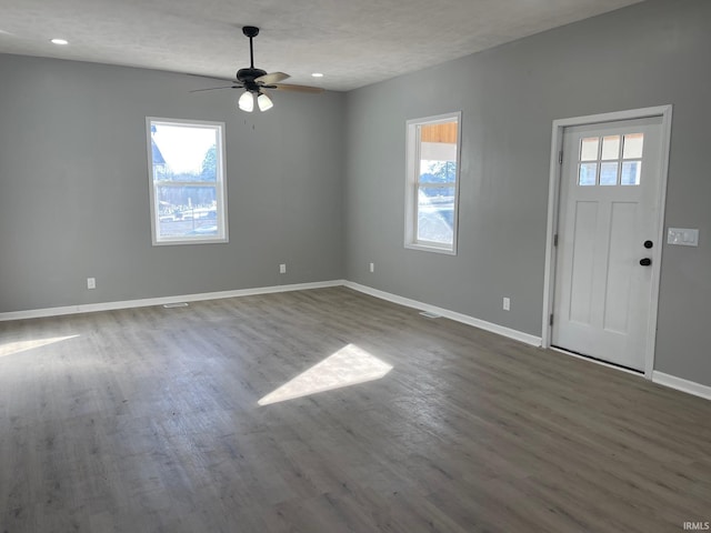 foyer entrance with dark wood-type flooring, ceiling fan, and a textured ceiling