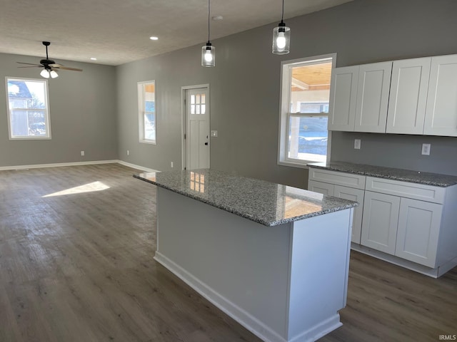 kitchen with ceiling fan, light stone countertops, pendant lighting, and white cabinets