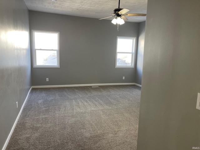 carpeted empty room with ceiling fan and a textured ceiling