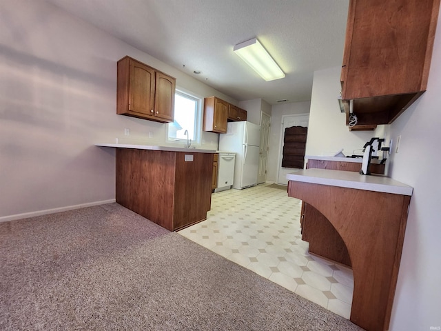 kitchen with sink, kitchen peninsula, and white appliances