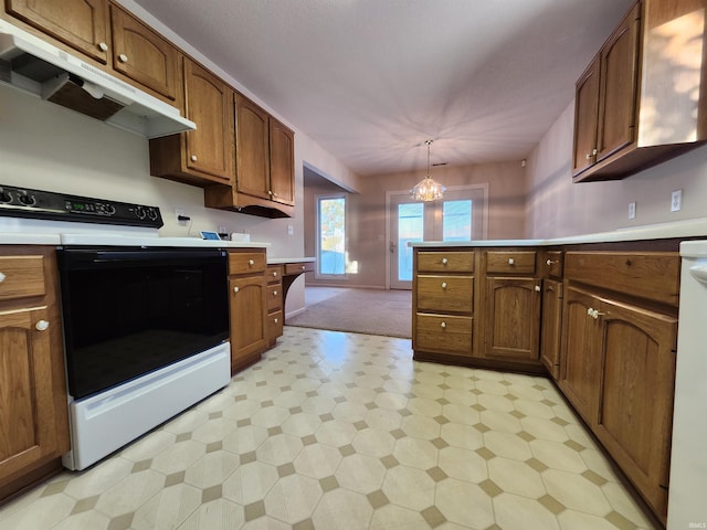 kitchen with electric stove, hanging light fixtures, kitchen peninsula, and an inviting chandelier