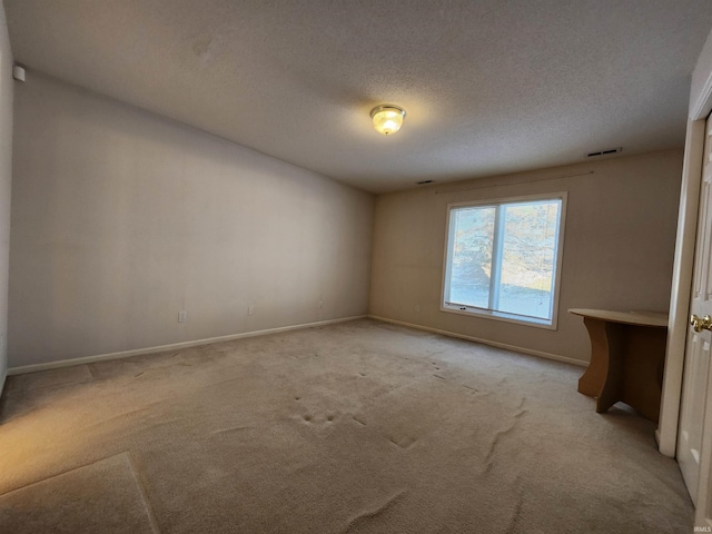 carpeted spare room featuring a textured ceiling