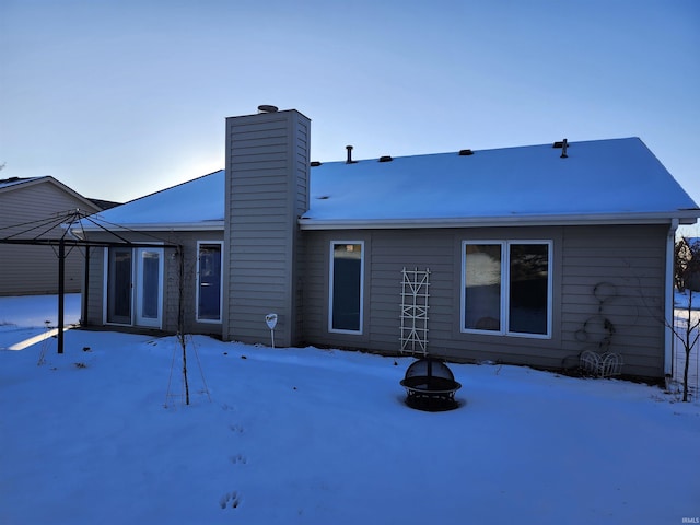 snow covered house featuring a fire pit