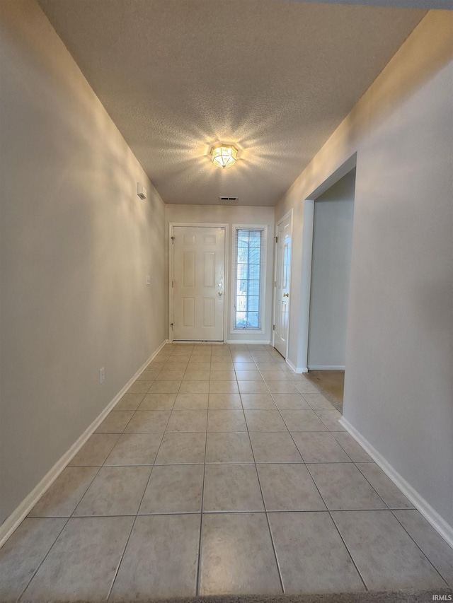 foyer featuring a textured ceiling and light tile patterned flooring