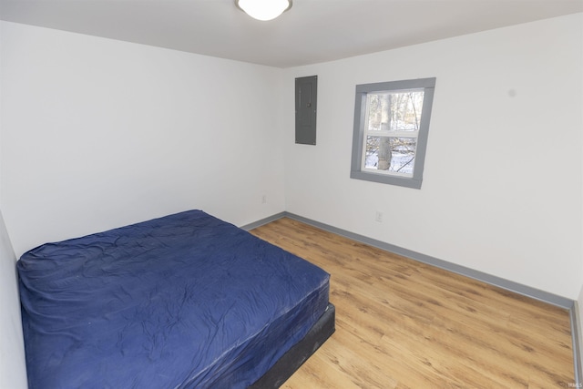 bedroom with hardwood / wood-style flooring and electric panel