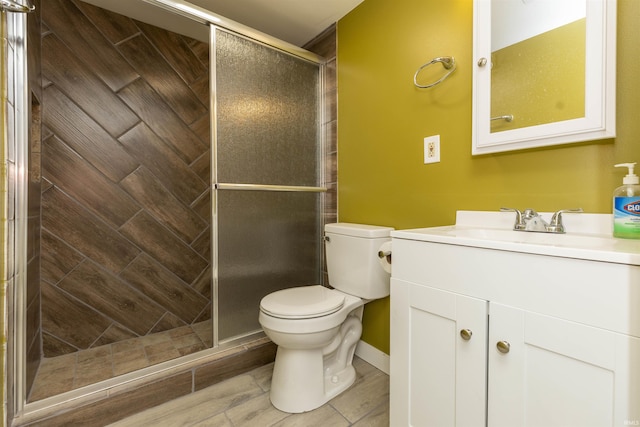 bathroom featuring a shower with shower door, toilet, and vanity