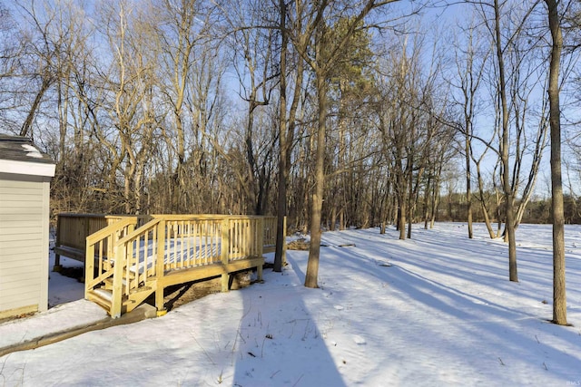 yard covered in snow with a wooden deck