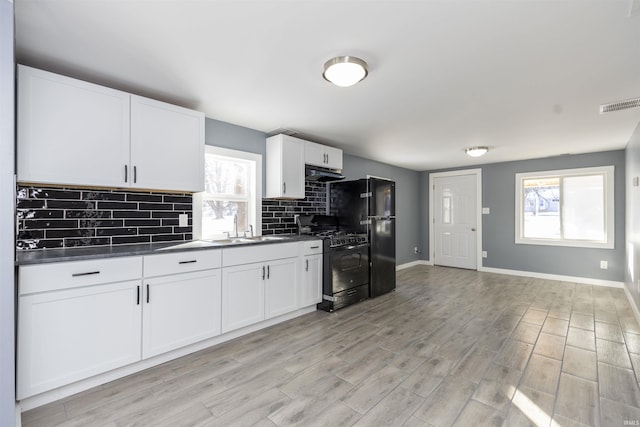 kitchen with white cabinetry, sink, plenty of natural light, and black appliances