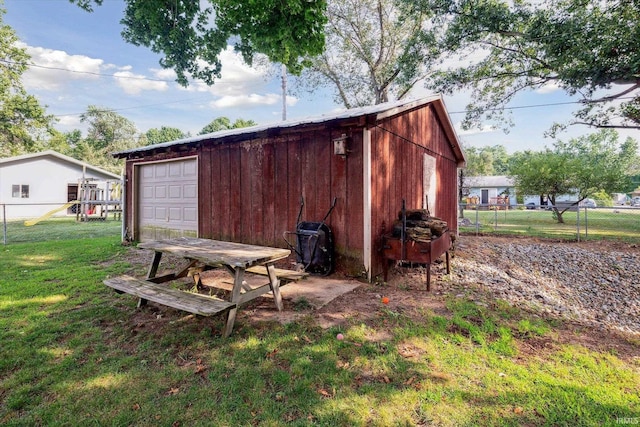 view of outdoor structure featuring a garage and a lawn