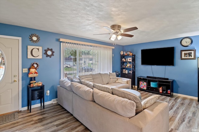 living room featuring hardwood / wood-style flooring, a textured ceiling, and ceiling fan