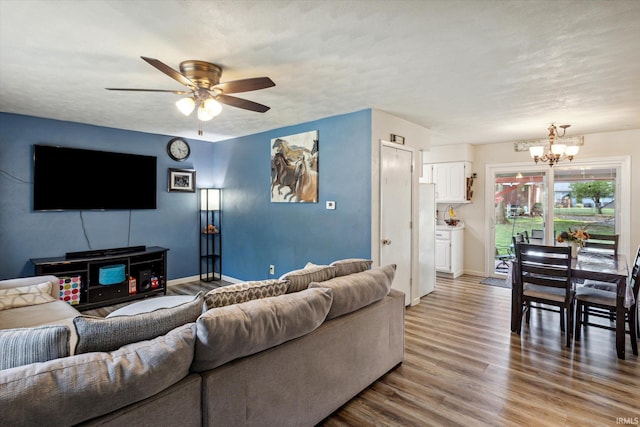 living room featuring a textured ceiling, ceiling fan with notable chandelier, and hardwood / wood-style flooring