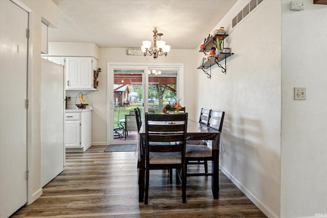 dining space featuring an inviting chandelier and dark hardwood / wood-style floors