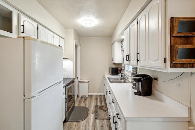 kitchen with stainless steel appliances, light hardwood / wood-style flooring, white cabinetry, and sink