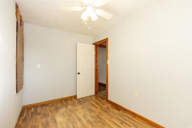 empty room with ceiling fan and hardwood / wood-style flooring