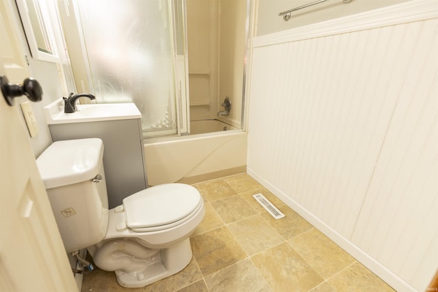 full bathroom featuring toilet, combined bath / shower with glass door, wood walls, and vanity