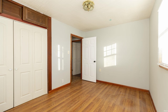 unfurnished bedroom featuring light hardwood / wood-style floors and a closet