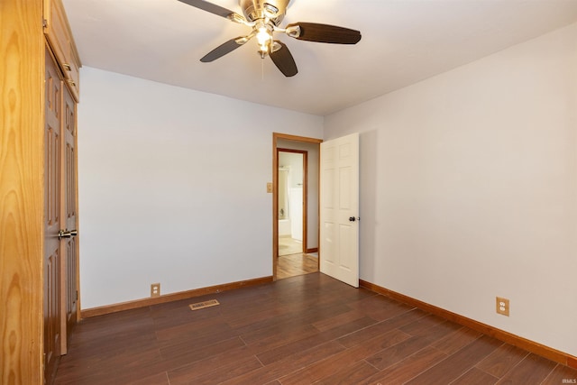 empty room with ceiling fan and dark hardwood / wood-style floors