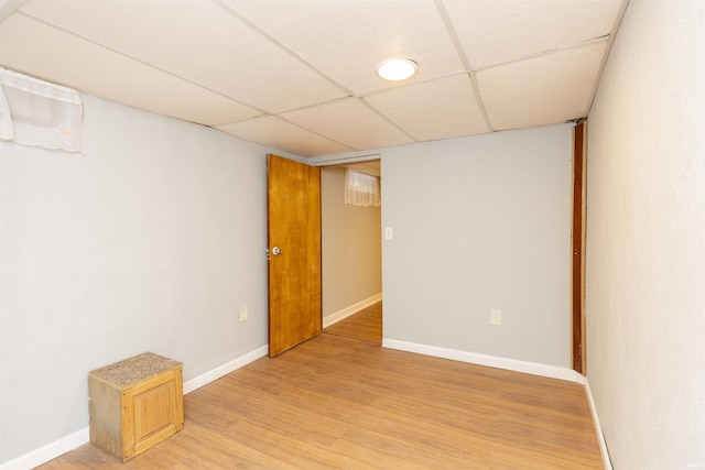 empty room with hardwood / wood-style flooring and a paneled ceiling