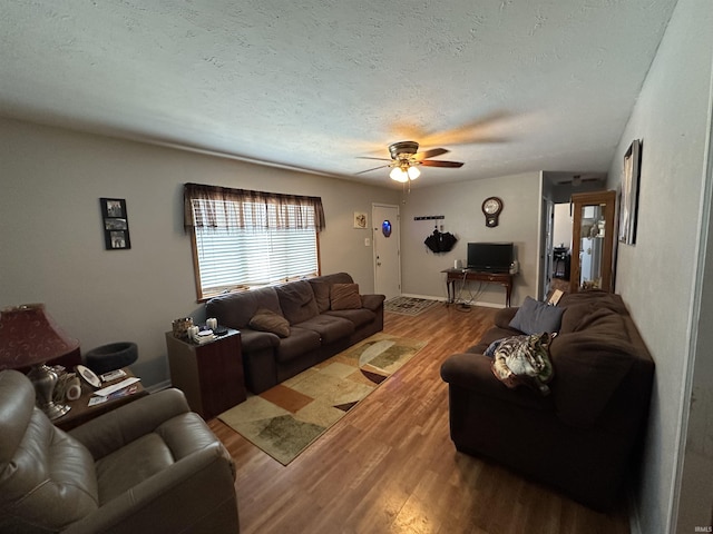 living room featuring hardwood / wood-style flooring, a textured ceiling, and ceiling fan