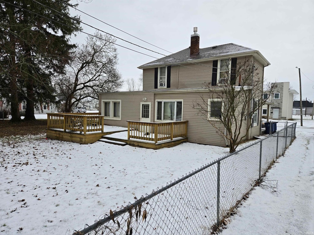 snow covered property with a wooden deck