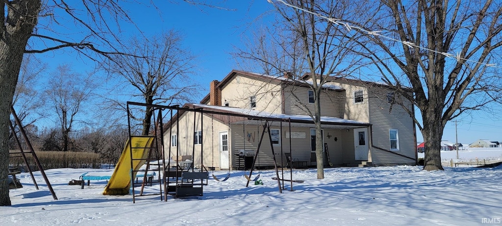 snow covered property featuring a playground