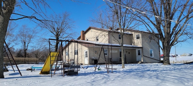 snow covered property featuring a playground