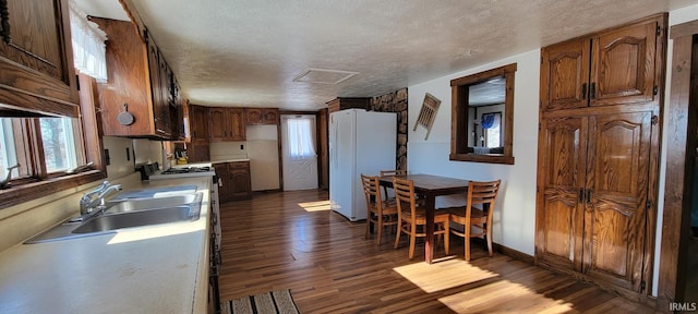 kitchen featuring white fridge, a textured ceiling, dark hardwood / wood-style floors, and sink