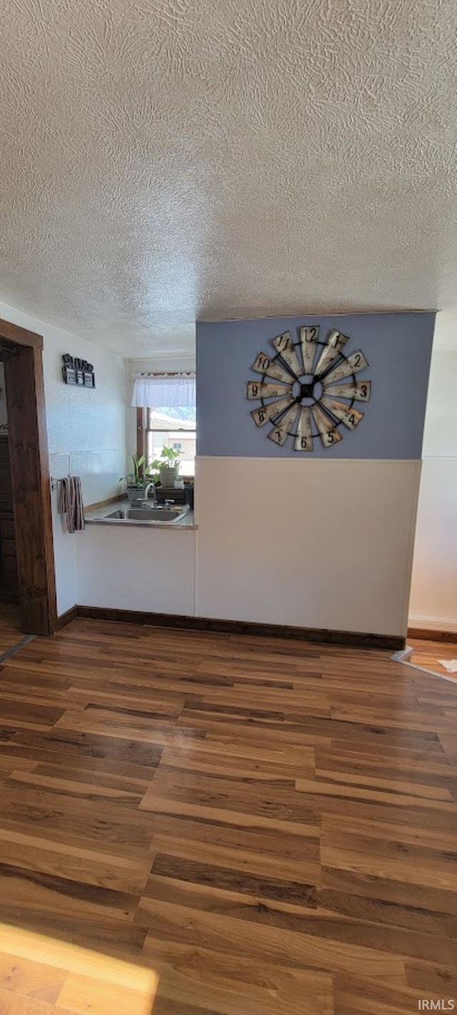 hall featuring wood-type flooring and a textured ceiling