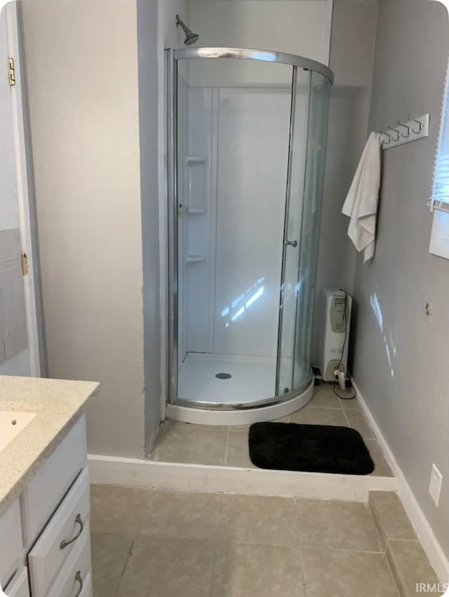 bathroom with an enclosed shower, vanity, and tile patterned floors