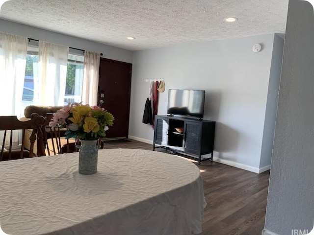 dining space with dark hardwood / wood-style flooring and a textured ceiling