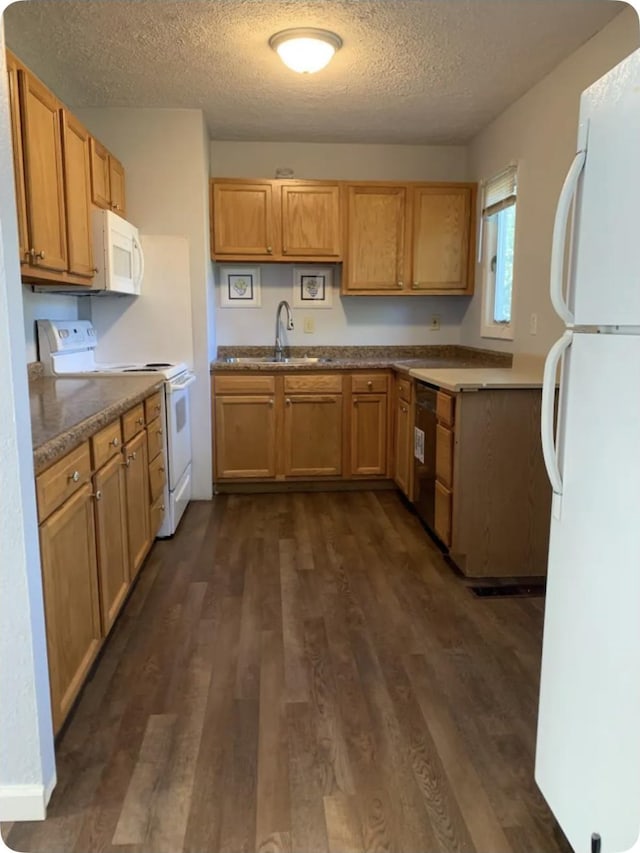 kitchen with sink, white appliances, dark hardwood / wood-style floors, and a textured ceiling