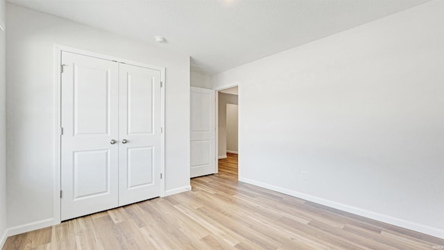 unfurnished bedroom featuring light wood-type flooring and a closet