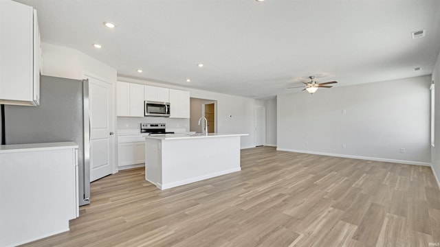 kitchen featuring appliances with stainless steel finishes, white cabinetry, an island with sink, sink, and ceiling fan