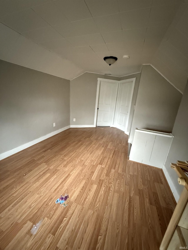 bonus room featuring wood-type flooring and vaulted ceiling