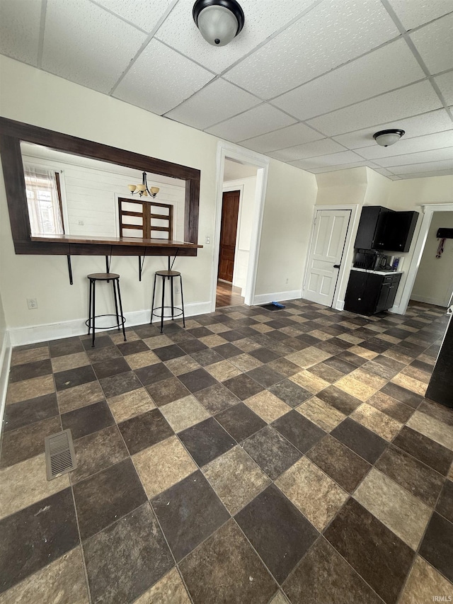 unfurnished living room featuring a drop ceiling