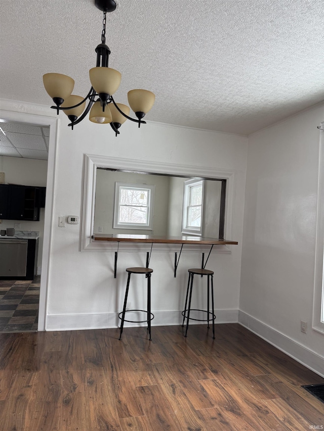 unfurnished dining area with dark wood-type flooring and an inviting chandelier