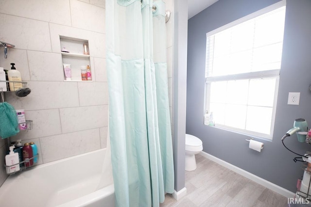 bathroom featuring shower / bath combo with shower curtain, plenty of natural light, hardwood / wood-style floors, and toilet