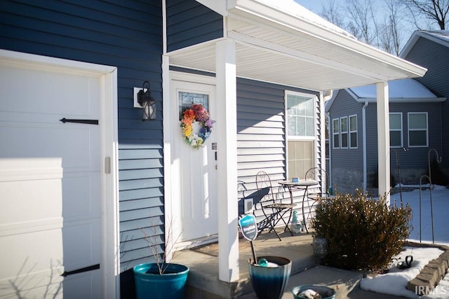 doorway to property with a porch and a garage